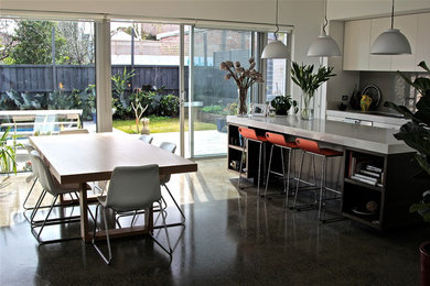 Design ideas for a mid-sized contemporary galley eat-in kitchen in Melbourne with an integrated sink, flat-panel cabinets, beige cabinets, quartz benchtops, grey splashback, glass sheet splashback, concrete floors and with island.