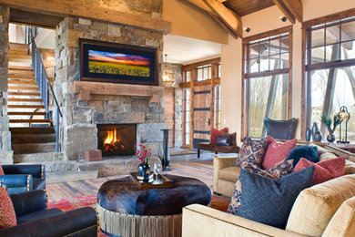 Inspiration for a mid-sized rustic formal and open concept light wood floor and brown floor living room remodel in Other with beige walls, a standard fireplace, a stone fireplace and no tv