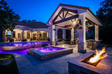 Photo of a large contemporary backyard custom-shaped pool in Houston with a pool house and natural stone pavers.