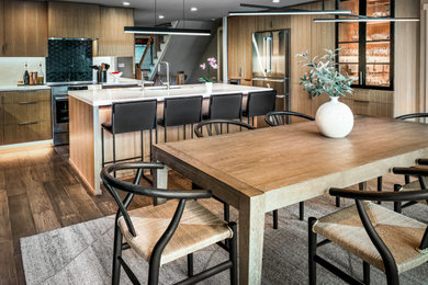 Mid-sized trendy vinyl floor and gray floor kitchen photo in Milwaukee with an undermount sink, flat-panel cabinets, light wood cabinets, quartz countertops, white backsplash, quartz backsplash, stainless steel appliances, an island and white countertops
