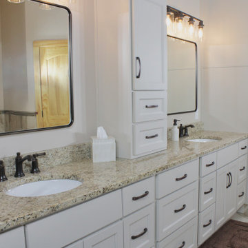 Custom white cabinetry, granite countertops, and generous storage complete this