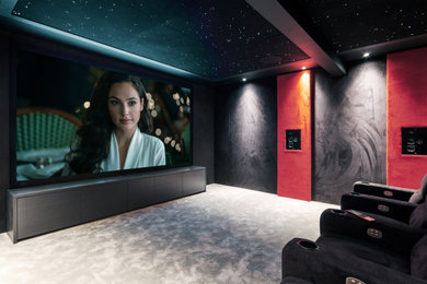 Design ideas for a mid-sized contemporary enclosed home theatre in Dorset with black walls, carpet, a projector screen and grey floor.