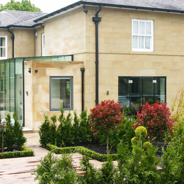 Grand limestone barn conversion and extension enhanced by contemporary frameless