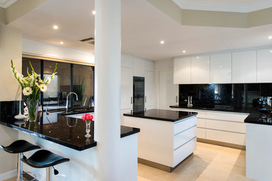 Inspiration for a modern u-shaped separate kitchen in Perth with an undermount sink, white cabinets, granite benchtops, black splashback, stone slab splashback, black appliances and with island.