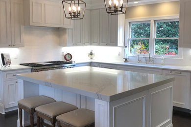 Eat-in kitchen - large traditional u-shaped dark wood floor and black floor eat-in kitchen idea in Charlotte with an undermount sink, raised-panel cabinets, white cabinets, quartzite countertops, white backsplash, subway tile backsplash, stainless steel appliances, an island and white countertops