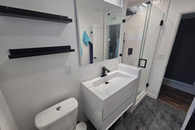Inspiration for a mid-sized modern white tile and ceramic tile ceramic tile, gray floor and single-sink corner shower remodel in Los Angeles with white cabinets, a one-piece toilet, white walls, an integrated sink, quartz countertops, white countertops and a floating vanity