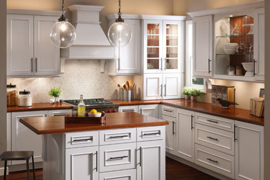 Enclosed kitchen - mid-sized transitional l-shaped medium tone wood floor and brown floor enclosed kitchen idea in Phoenix with recessed-panel cabinets, beige cabinets, wood countertops, stainless steel appliances and an island