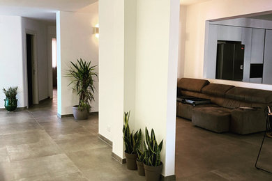 Esempio di un grande ingresso o corridoio minimalista con pareti bianche, pavimento in gres porcellanato, pavimento grigio e soffitto ribassato