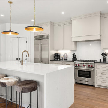 Sleek and spacious kitchen featuring quartz waterfall countertops, soft-close ca