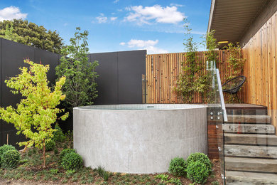 Design ideas for a mid-sized contemporary backyard round aboveground pool in Melbourne with decking.