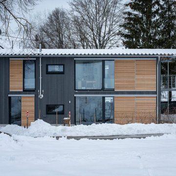 Kleines schwarzes Wohnhaus in Winterlandschaft