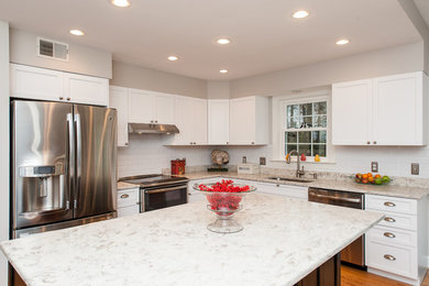 Eat-in kitchen - mid-sized transitional l-shaped light wood floor eat-in kitchen idea in DC Metro with an undermount sink, shaker cabinets, white cabinets, white backsplash, subway tile backsplash, stainless steel appliances, an island and granite countertops