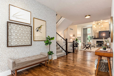 Mid-sized 1950s medium tone wood floor and beige floor entryway photo in Columbus with multicolored walls and a yellow front door