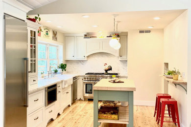 Mid-sized country l-shaped eat-in kitchen in Sacramento with a farmhouse sink, beaded inset cabinets, white cabinets, marble benchtops, white splashback, marble splashback, stainless steel appliances, light hardwood floors, with island, brown floor, white benchtop and timber.