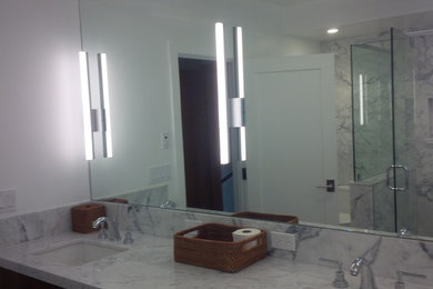 Ejemplo de cuarto de baño principal minimalista con armarios con puertas mallorquinas, puertas de armario de madera oscura, encimera de mármol, baldosas y/o azulejos blancos y baldosas y/o azulejos de piedra