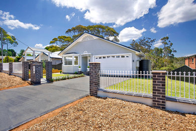 Photo of a traditional one-storey grey house exterior in Sydney with wood siding and a metal roof.