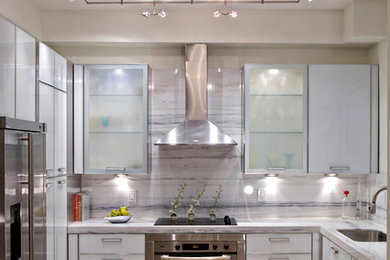 This is an example of a mid-sized contemporary u-shaped eat-in kitchen in Miami with an undermount sink, flat-panel cabinets, grey cabinets, stainless steel appliances, quartz benchtops, travertine floors and no island.