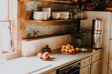 Eat-in kitchen - cottage galley dark wood floor, brown floor and exposed beam eat-in kitchen idea in Other with a farmhouse sink, shaker cabinets, green cabinets, concrete countertops, beige backsplash, limestone backsplash, black appliances and gray countertops