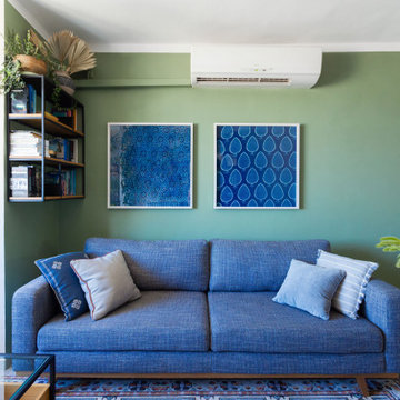 Blaues Sofa vor salbeigrüner Wand