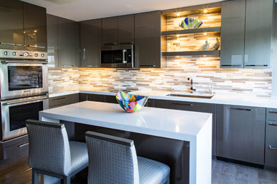Inspiration for a large modern u-shaped separate kitchen in Chicago with an undermount sink, flat-panel cabinets, grey cabinets, solid surface benchtops, beige splashback, mosaic tile splashback, stainless steel appliances, dark hardwood floors, with island and brown floor.