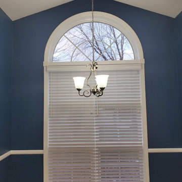 white blinds in bay and under arched windows