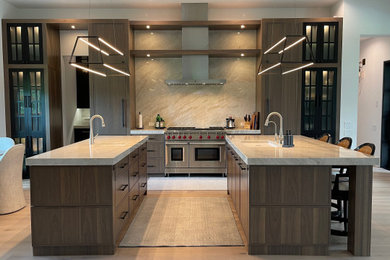 Immagine di una grande cucina abitabile minimalista con lavello sottopiano, ante con riquadro incassato, ante in legno scuro, top in quarzite, elettrodomestici in acciaio inossidabile e 2 o più isole