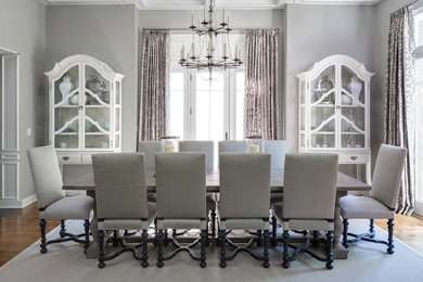 Enclosed dining room - large transitional medium tone wood floor and brown floor enclosed dining room idea in New York with gray walls