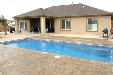 Стильный дизайн: прямоугольный бассейн среднего размера на заднем дворе в стиле фьюжн с мощением клинкерной брусчаткой - последний тренд