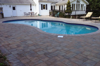 Inspiration for a mid-sized traditional backyard kidney-shaped aboveground pool in Baltimore with concrete pavers.