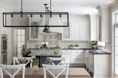 Design ideas for a large traditional l-shaped open plan kitchen in New York with a farmhouse sink, recessed-panel cabinets, white cabinets, quartzite benchtops, ceramic splashback, panelled appliances, dark hardwood floors, with island, brown floor and multi-coloured benchtop.