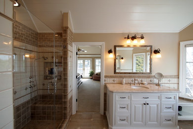 This is an example of a large transitional master bathroom in San Francisco with recessed-panel cabinets, white cabinets, a freestanding tub, an alcove shower, a two-piece toilet, beige tile, brown tile, white tile, cement tile, beige walls, porcelain floors, an undermount sink, granite benchtops, brown floor and a hinged shower door.