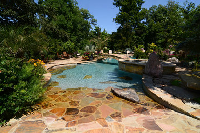 Large elegant backyard stone and custom-shaped natural hot tub photo in Cincinnati