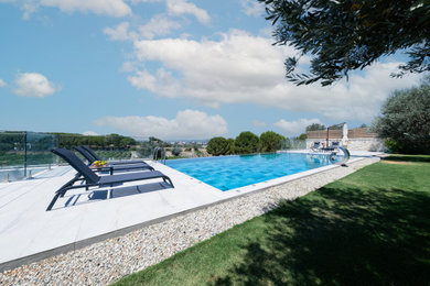 Pool - backyard tile and rectangular pool idea in Other