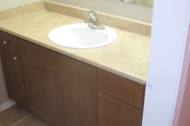 Example of a classic beige tile powder room design in Edmonton with flat-panel cabinets and medium tone wood cabinets