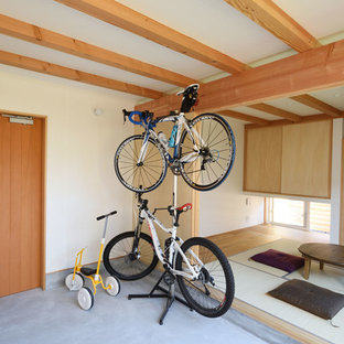 他の地域の片開きドアアジアンスタイルのおしゃれな玄関 (白い壁、コンクリートの床、木目調のドア、グレーの床) の写真