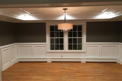 Dining room with a coffered ceiling, raised panel wainscoting and custom baseboa