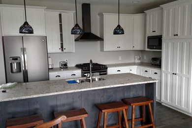 Eat-in kitchen - mid-sized traditional l-shaped dark wood floor eat-in kitchen idea in Minneapolis with a double-bowl sink, shaker cabinets, white cabinets, granite countertops, stainless steel appliances and an island