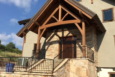 Inspiration for a large craftsman exposed beam single front door remodel in Denver with beige walls and a dark wood front door