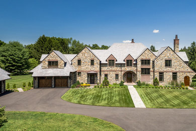 Example of a classic beige two-story stone exterior home design in Wilmington with a shingle roof