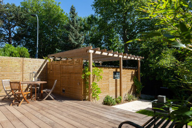 Cette photo montre un jardin avec pergola avant chic de taille moyenne et l'été avec une exposition ensoleillée et une terrasse en bois.