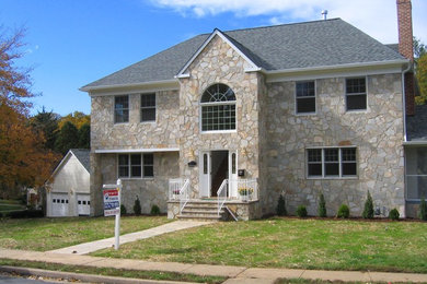 Large beige two-story stone exterior home idea in DC Metro with a hip roof