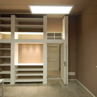 Idéer för att renovera ett stort funkis arbetsrum, med ett bibliotek, bruna väggar, kalkstensgolv, en standard öppen spis, en spiselkrans i betong, ett fristående skrivbord och grått golv