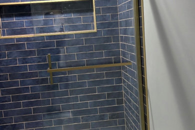 Example of a mid-sized transitional blue tile and ceramic tile porcelain tile and white floor bathroom design in Columbus with a niche