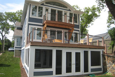 Mid-sized beach style three-storey blue house exterior in Grand Rapids with vinyl siding, a hip roof and a mixed roof.