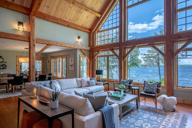 Mountain style open concept medium tone wood floor and brown floor living room photo in Portland Maine with gray walls
