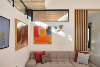 Example of a trendy light wood floor and brown floor living room design in Austin with a wall-mounted tv