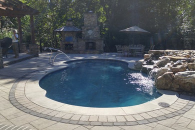 Fiberglass pool with pavers and water feature