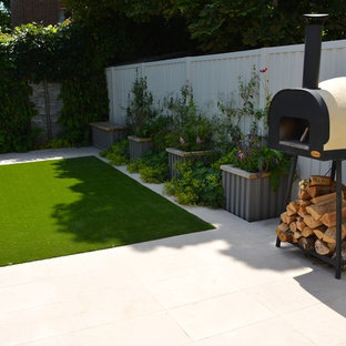 Photo of a mid-sized contemporary backyard full sun formal garden for summer in London with a vertical garden and natural stone pavers.
