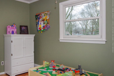 Foto de dormitorio infantil de 1 a 3 años de tamaño medio con paredes verdes, suelo de madera clara y suelo multicolor