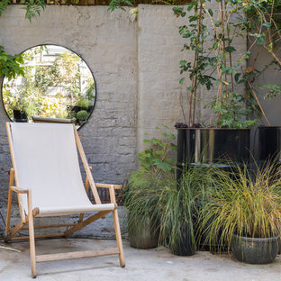 This is an example of an industrial courtyard partial sun garden in London with a garden path.
